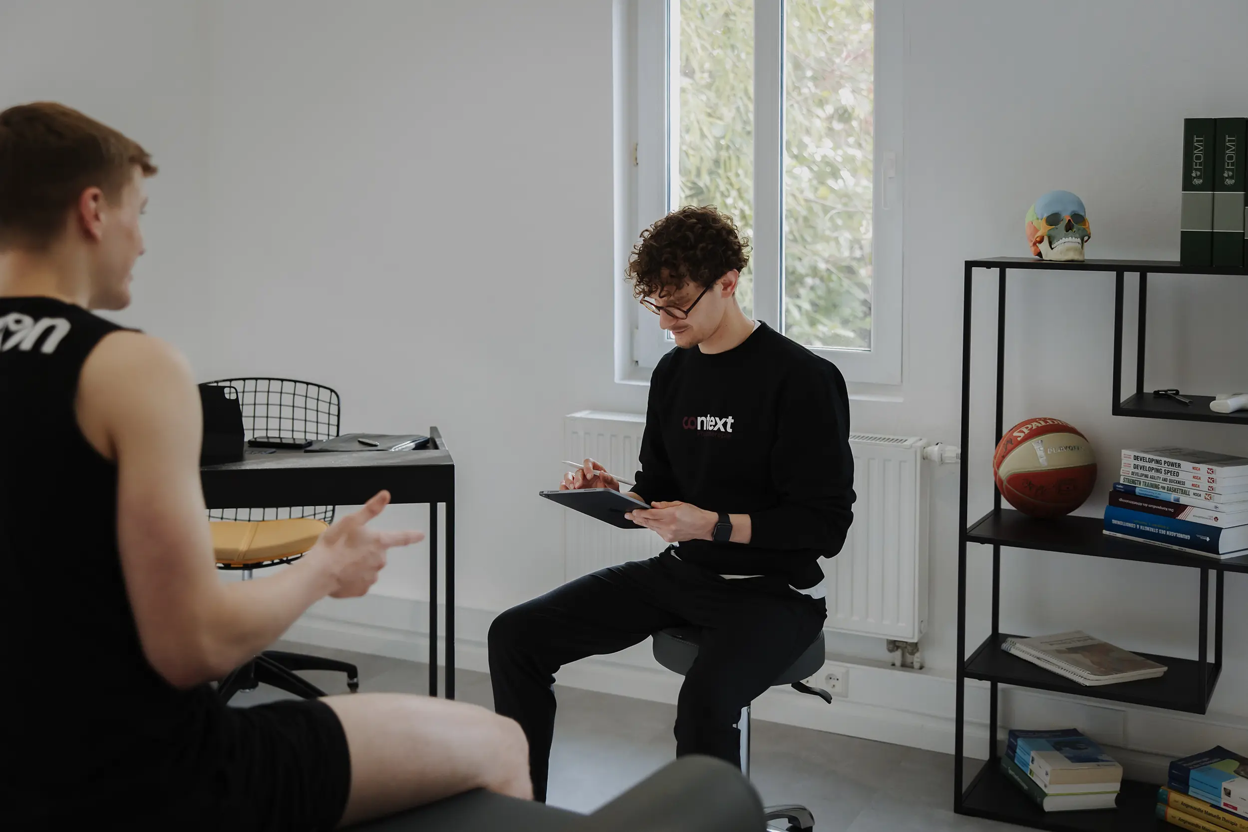 Tobi, Inhaber und Physiotherapeut von context.physio Ludwigsburg, wie er einen Kunden berät